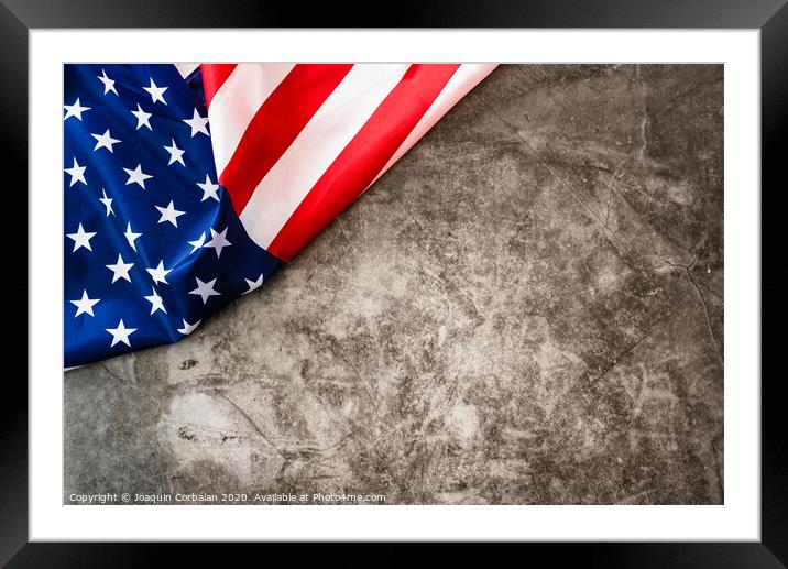 Striking colored American flag isolated in a corner on a stone gray background. Framed Mounted Print by Joaquin Corbalan