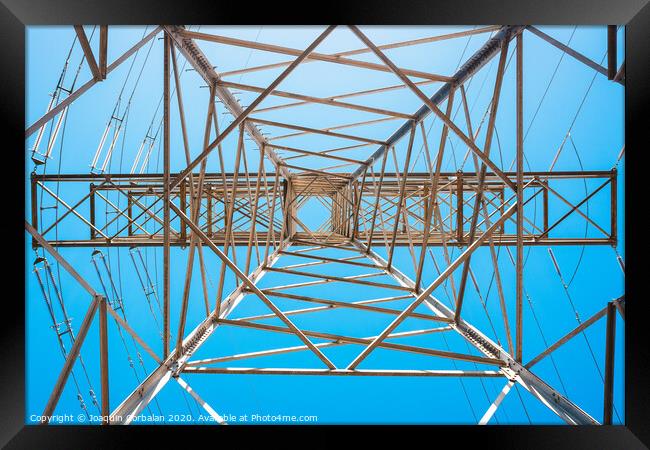 Electricity is transported by thick cables attached to metal towers. Framed Print by Joaquin Corbalan