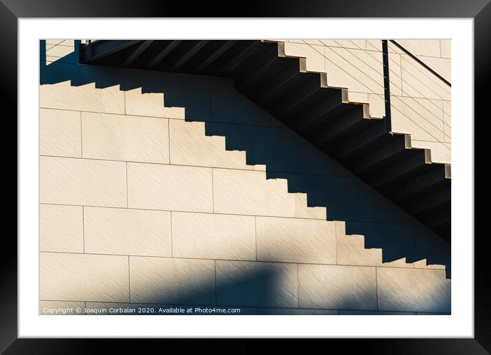Minimalist wall with shadows from the upper steps of a modern stone staircase. Framed Mounted Print by Joaquin Corbalan