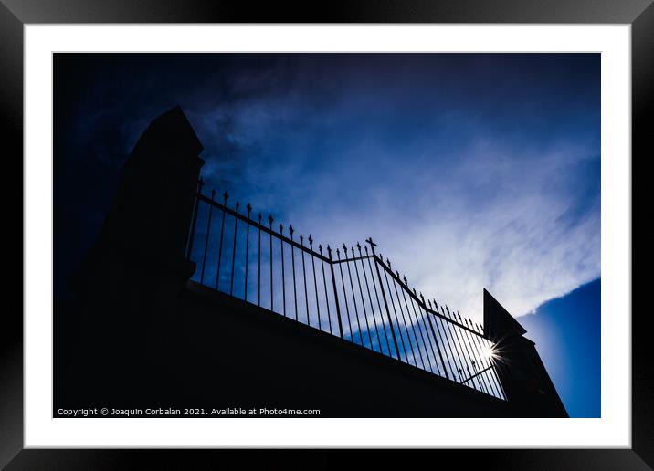 Metal grating of a cemetery with a cross on a white wall, copy s Framed Mounted Print by Joaquin Corbalan