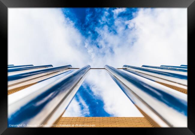 Fence with tall metal bars pointing to the blue sky with perspec Framed Print by Joaquin Corbalan