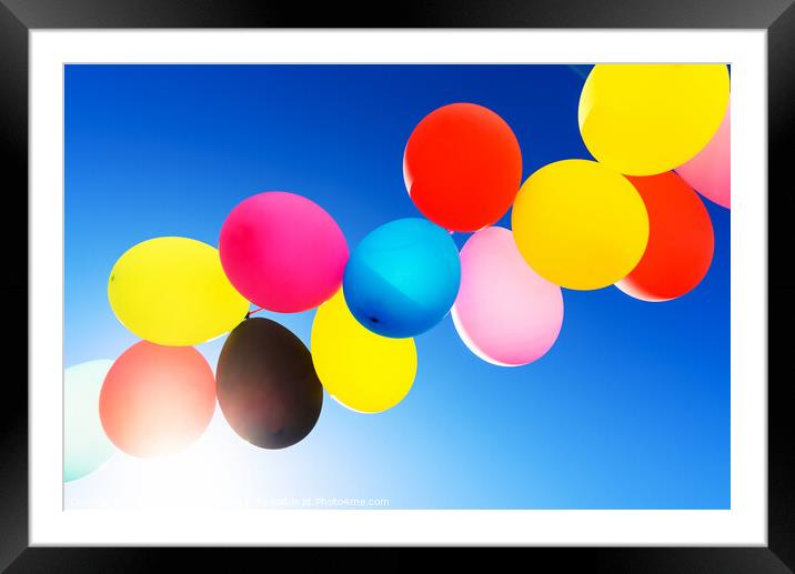 Colorful balloons inflated against the sun, festive and joyful c Framed Mounted Print by Joaquin Corbalan