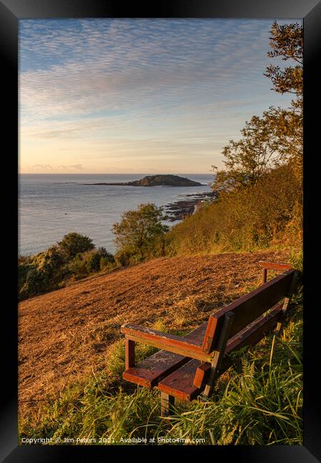 Wooden bench overlooking Looe bay & Looe island in the early morning sun Framed Print by Jim Peters