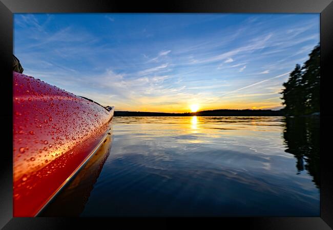 red plastic kayak on calm water in the sunset Framed Print by Jonas Rönnbro