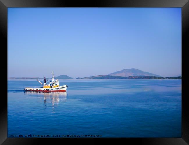 small colorful fishing boat in calm water  Framed Print by Florin Brezeanu