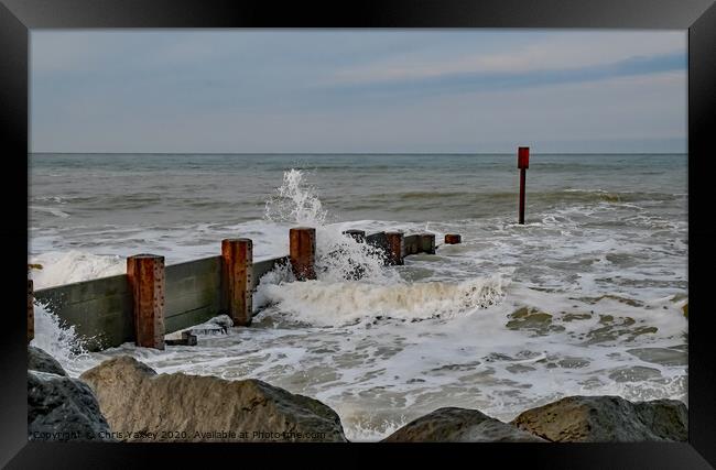 Waves crashing over the wooden groynes at high tide on Cart Gap beach Framed Print by Chris Yaxley