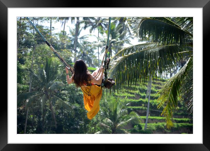 Young woman swinging in the jungle rainforest of Bali, Indonesia Framed Mounted Print by Yann Tang