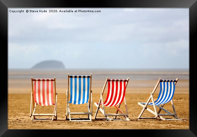 Colourful wooden deck chairs on a beach Framed Print by Steve Hyde