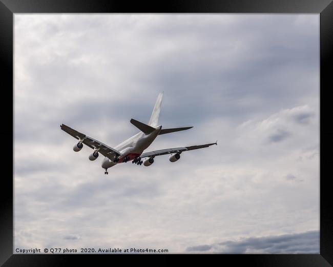 Passenger plane flying in the blue sky with clouds Framed Print by Q77 photo