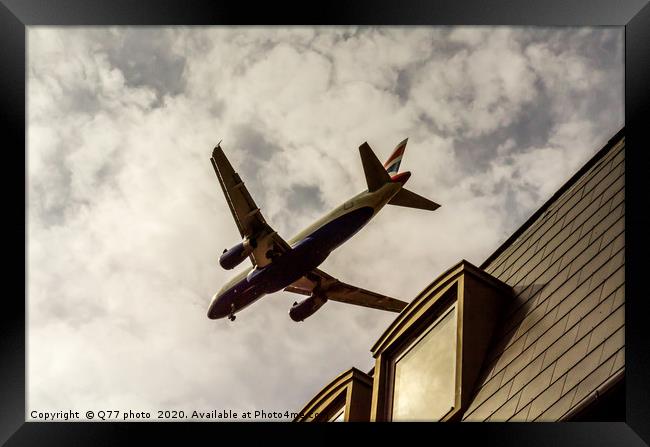 Passenger plane flying over the roofs of residenti Framed Print by Q77 photo