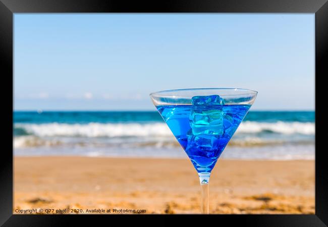 drink in a martini glass on the background of the waves affecting the sandy beach, relax on the beach, refreshing drink during the holidays Framed Print by Q77 photo