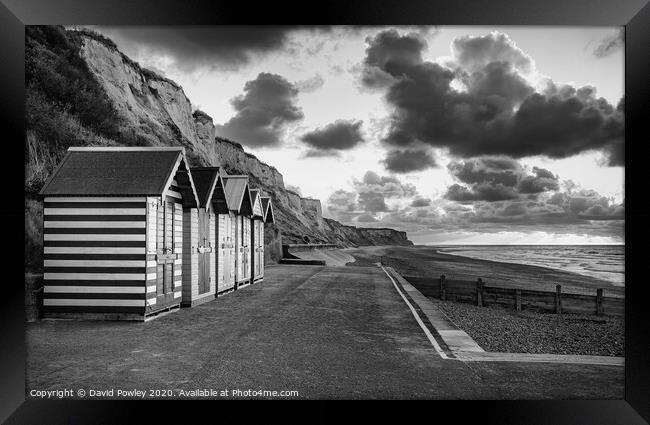 Cromer beach huts at sunset monochrome Framed Print by David Powley