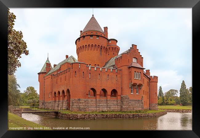a romantic red castle with a tall tower surrounded by a moat Framed Print by Stig Alenäs