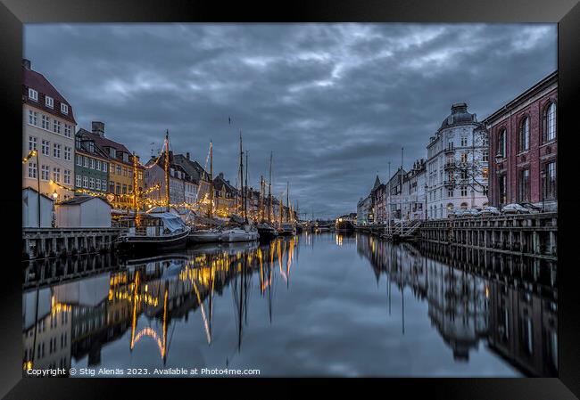 Christmas decorations in Nyhavn are reflected in the water durin Framed Print by Stig Alenäs