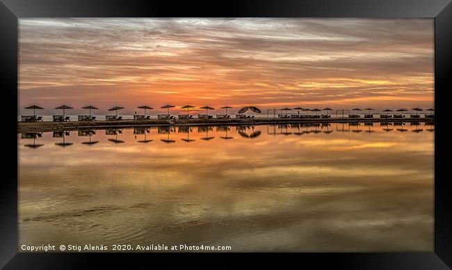 sunbeds and parasols in a long row at sunset  Framed Print by Stig Alenäs