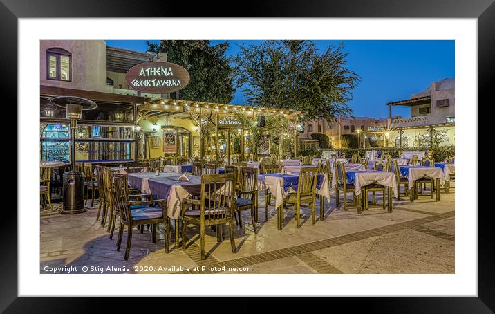 illuminated greek taverna with tables and chairs i Framed Mounted Print by Stig Alenäs