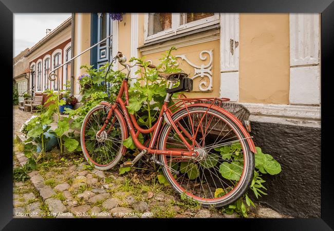 a red retro bike leaning up against a wall with ho Framed Print by Stig Alenäs