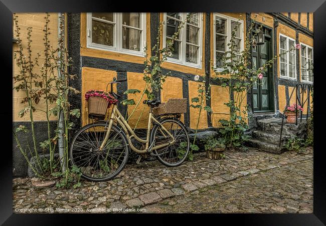 yellow bike leaning against a yellow half-timbered Framed Print by Stig Alenäs