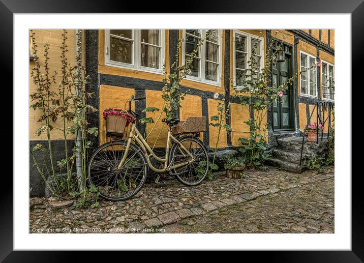yellow bike leaning against a yellow half-timbered Framed Mounted Print by Stig Alenäs
