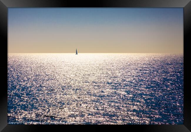 A backlit sailboat at sea Framed Print by Jordi Carrio