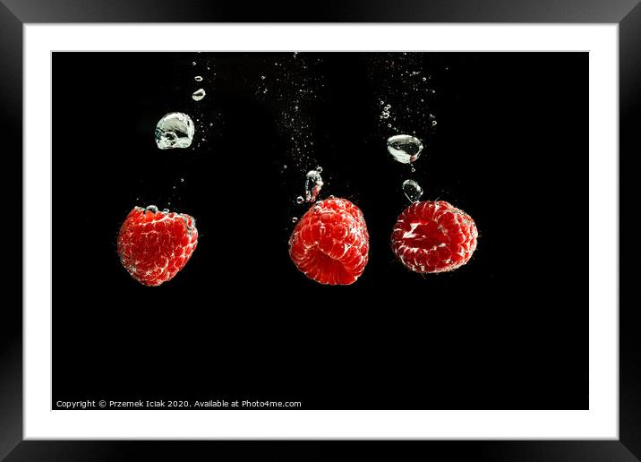 Raspberries splashing into clear water isolated on black background. Framed Mounted Print by Przemek Iciak