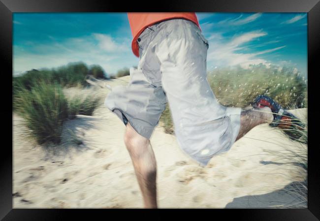 blurry photo of man legs running through sand Framed Print by federico stevanin