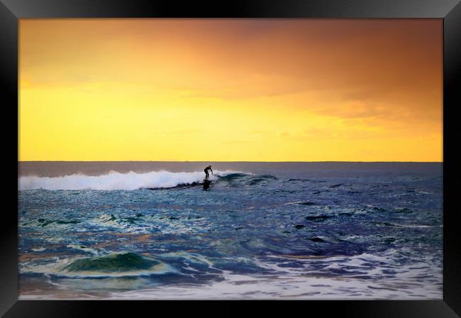  lone surfer rides the wave of the ocean at sunset Framed Print by federico stevanin