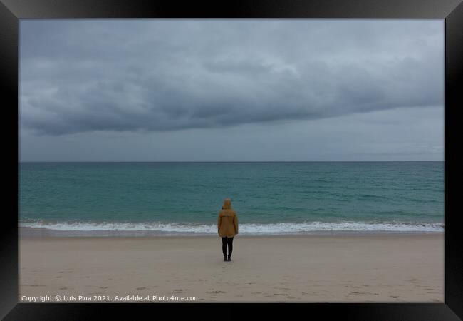 Woman girl with yellow jacket on an empty beach with stormy weather and turquoise water Framed Print by Luis Pina
