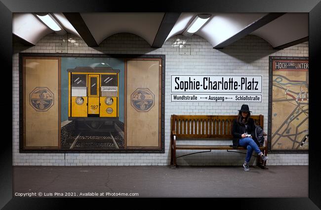 Woman sitting on a bench at Sophie Charlotte Platz subway station in Berlin Framed Print by Luis Pina
