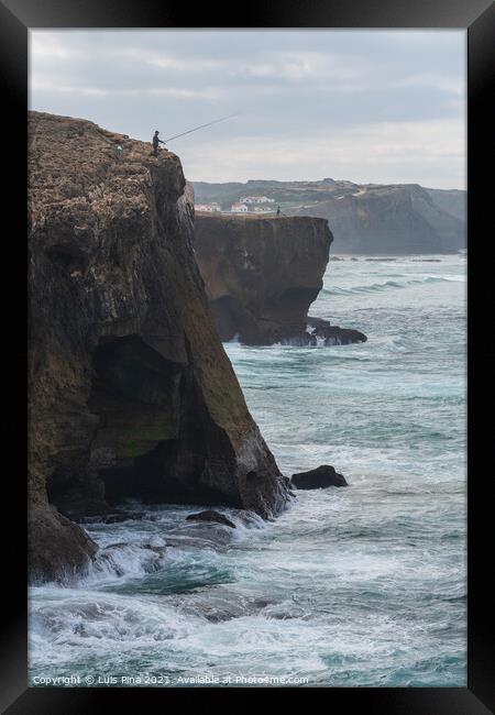 Fishermen fishing in Praia de Aljezur beach sea cliff edge, in Portugal Framed Print by Luis Pina