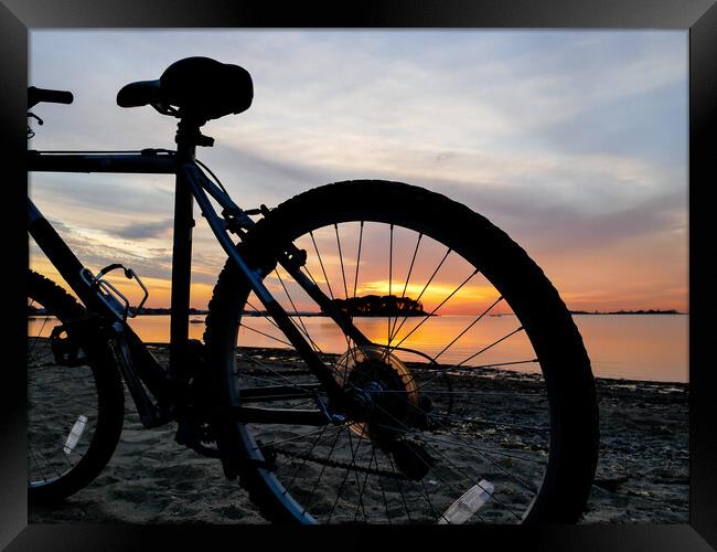 Bike silhouette and sunrise light on beach Framed Print by Miro V