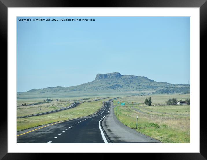 Endless ribbon of blacktop heading towards a mesa  Framed Mounted Print by William Jell