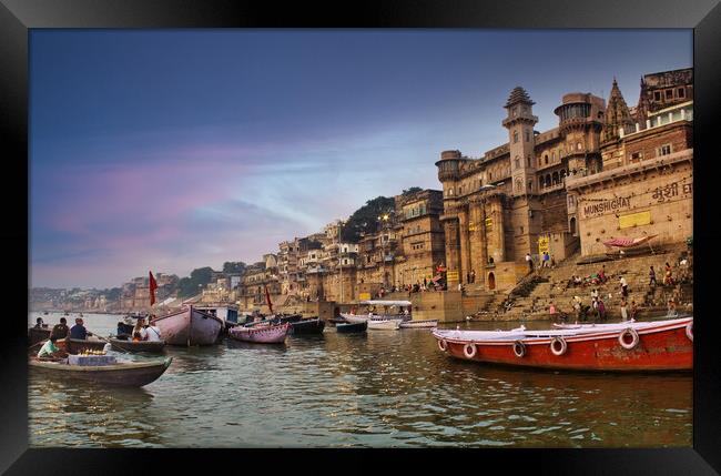 Varanasi, India : People and tourists on wooden boat sightseeing in Ganges river near Munshi ghat against ancient city architecture as viewed from a boat during morning time Framed Print by Arpan Bhatia