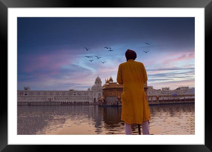 Amritsar, India: Unidentified Sikh Guard with spear standing and looking around near Sri Harmandir Sahib or Golden Temple pond against dramatic sunrise and birds in the sky Framed Mounted Print by Arpan Bhatia
