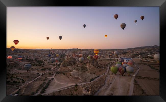 Cappadocia, Turkey - September 14, 2021: Wide angle aerial panoramic shot of colorful hot air balloons together floating in the sky at early morning sunrise horizon in Goreme national park Framed Print by Arpan Bhatia