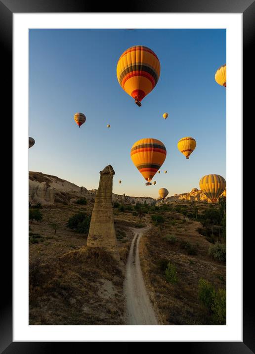 Vertical image of bunch of colorful hot air balloon flying early morning in Cappadocia, Turkey against typical rock formation due to volcanic activity in love valley located in Goreme national park Framed Mounted Print by Arpan Bhatia