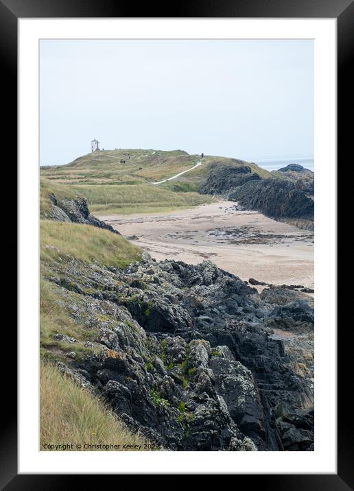 Rocky beach and lighthouse of Ynys Llanddwyn Framed Mounted Print by Christopher Keeley