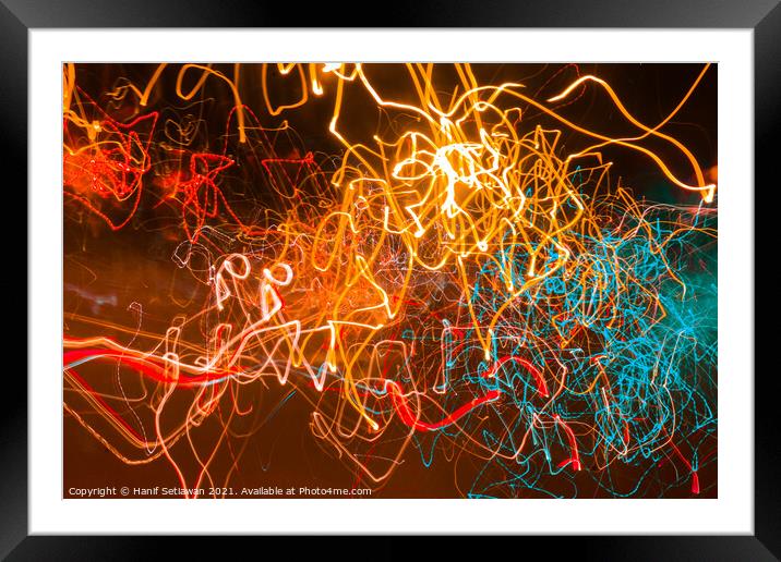 Abstract shapes of glowing swirled neon light Framed Mounted Print by Hanif Setiawan