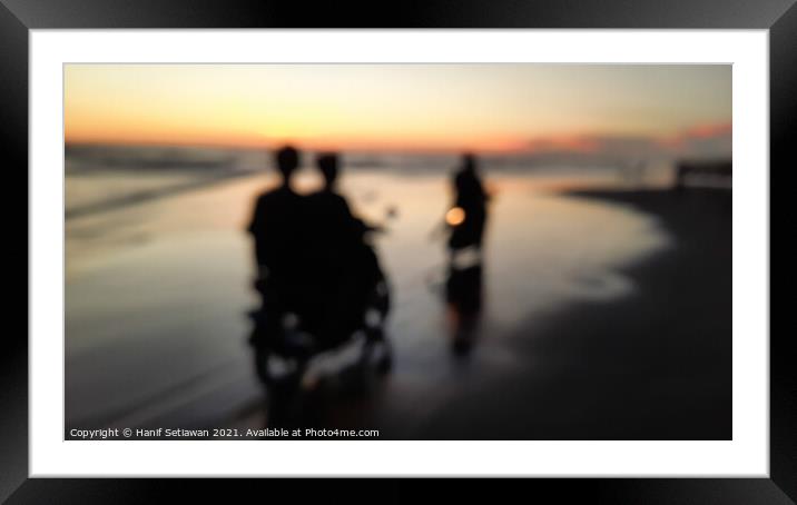 Young people motorcycling on a wet sand beach Framed Mounted Print by Hanif Setiawan