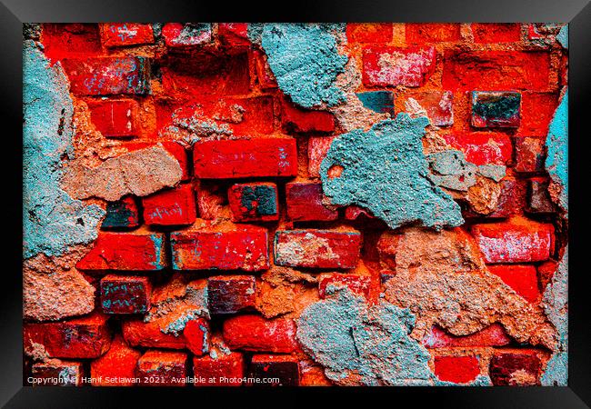 A damaged brick wall in digital red turquoise blue Framed Print by Hanif Setiawan