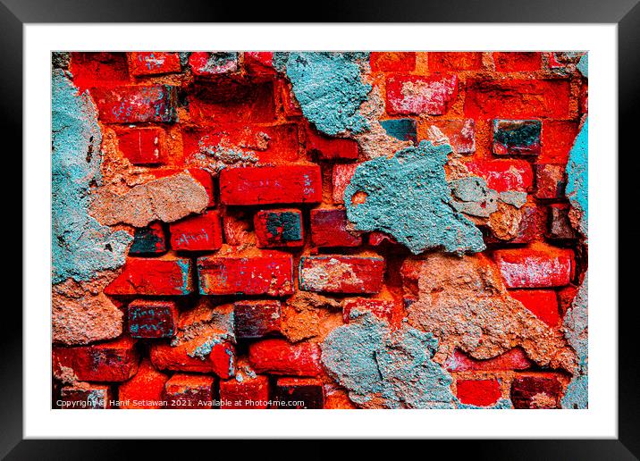 A damaged brick wall in digital red turquoise blue Framed Mounted Print by Hanif Setiawan