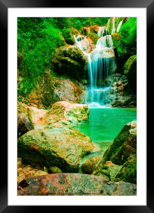 A waterfall flowing over rocks into a lake. Framed Mounted Print by Hanif Setiawan