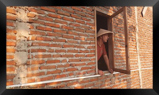 A Caucasian man in window with conical hat. Framed Print by Hanif Setiawan