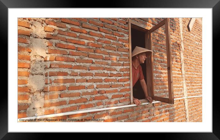 A Caucasian man in window with conical hat. Framed Mounted Print by Hanif Setiawan