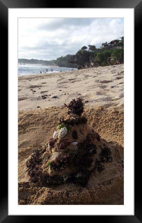Santa Claus built from sand seaweed and stones at a sand beach 2a Framed Mounted Print by Hanif Setiawan