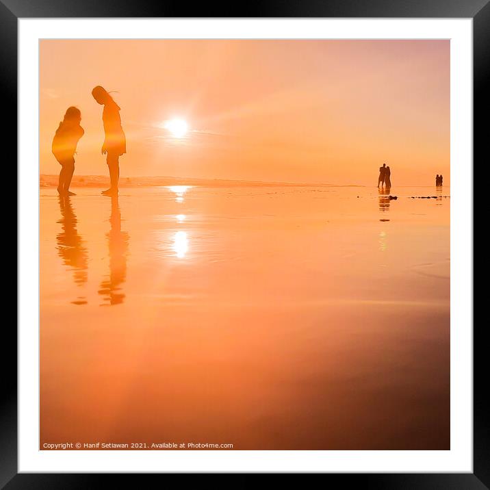 Silhouetted people in a row on sand beach Squared Framed Mounted Print by Hanif Setiawan