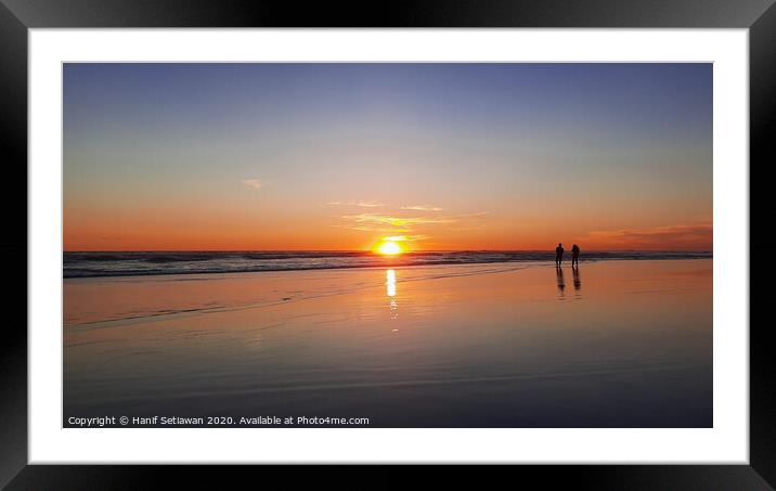 Silhouetted couple enjoys sunset at beach 1 Framed Mounted Print by Hanif Setiawan