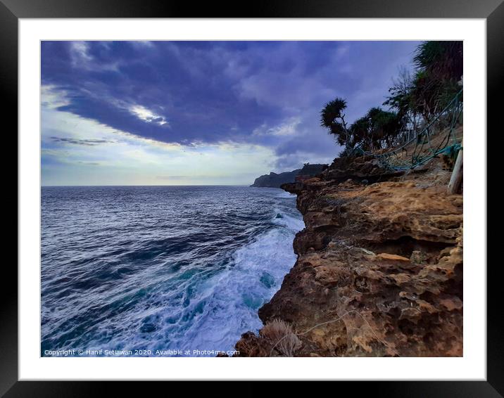 Big waves crashing against a steep rock Framed Mounted Print by Hanif Setiawan