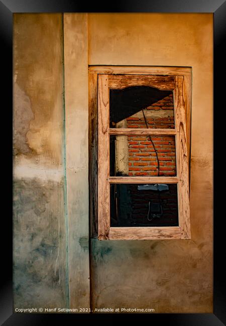 A wooden window on yellow brown wall. Framed Print by Hanif Setiawan