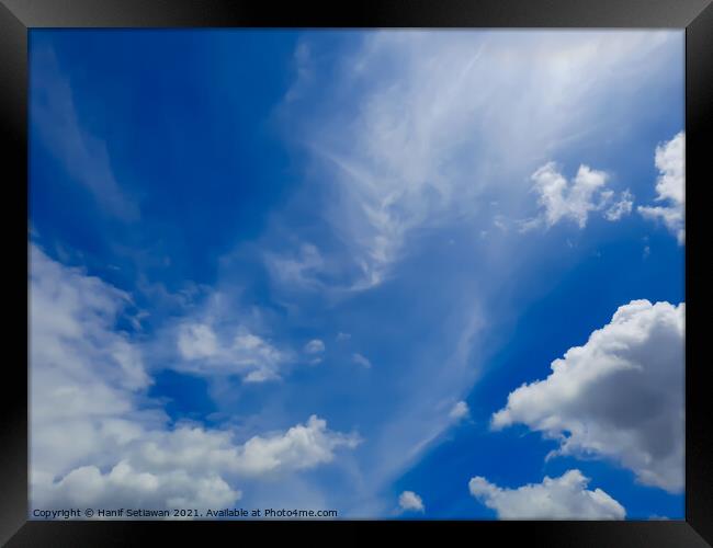 Fluffy white cloud shapes at blue sky. Framed Print by Hanif Setiawan